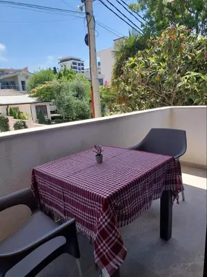 a table with a red and white checkered table cloth on a balcony at Top Apartments in Dobra Voda