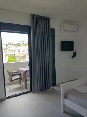 a bedroom with a bed and a table and a window at Top Apartments in Dobra Voda