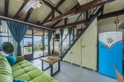 a living room with a green couch and a stairs at Guest House Vrelo in Virpazar