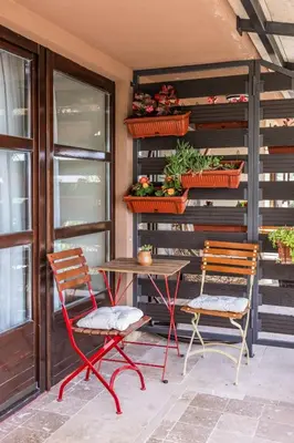 a patio with two chairs and a table and some plants at Guest House Vrelo in Virpazar