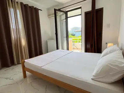 a bedroom with a large bed with a large window at Apartments Sara 2 in Ulcinj