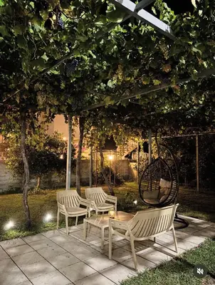 two benches and a table under a tree at night at Apartments Sara 2 in Ulcinj