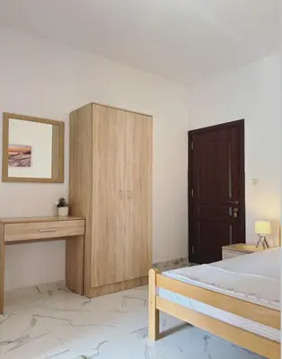 a bedroom with a bed and a wooden cabinet at Apartments Sara 2 in Ulcinj