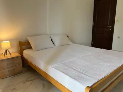 a bedroom with a bed with a night stand and a lamp at Apartments Sara 2 in Ulcinj