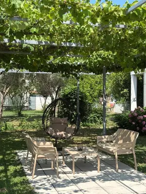 a group of chairs and a bench under a pergola at Apartments Sara 2 in Ulcinj