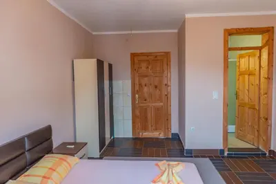 a bedroom with a bed and a refrigerator and a door at Nomad apartments in Ulcinj