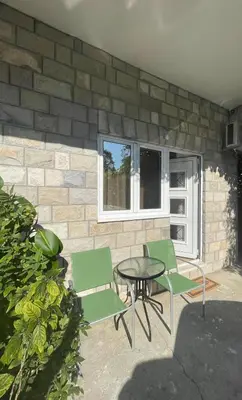 a patio with chairs and a table and a brick wall at Apartments KinGs in Petrovac na Moru