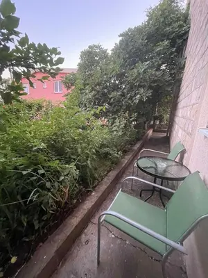 a patio with a table and chairs and trees at Apartments KinGs in Petrovac na Moru