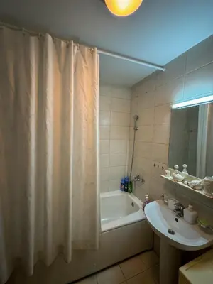 a bathroom with a shower curtain and a sink at Apartment 50 in Podgorica