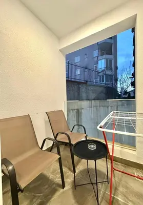 a balcony with two chairs and a table and a window at Modern One bedroom Apartment Budva in Budva