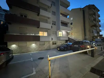 a parking lot with cars parked in front of a building at Modern One bedroom Apartment Budva in Budva