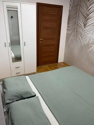 a bedroom with a bed and a wooden door at Royal in Podgorica