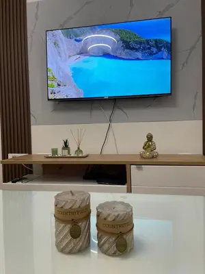 a living room with a tv and two stools at Royal in Podgorica