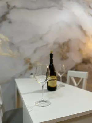 a bottle of wine and a wine glass on a table at Royal in Podgorica