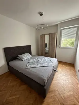 a bedroom with a bed in a room with a window at Apartman Budva 1 in Budva