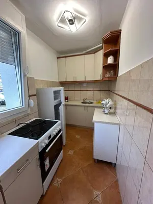 a kitchen with a stove and a white refrigerator at Apartman Budva 1 in Budva