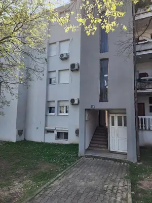 a white building with a door and stairs at Apartman Budva 1 in Budva