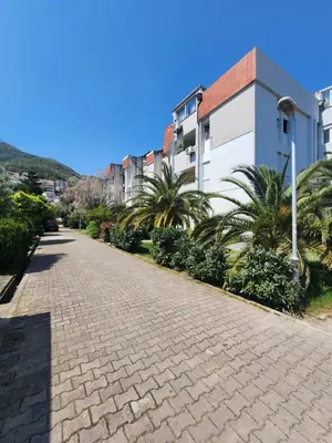 a cobblestone street with palm trees and buildings at Apartman Budva 1 in Budva