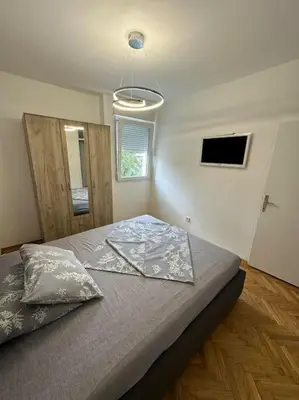a bedroom with a large bed with a light at Apartman Budva 1 in Budva