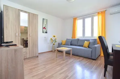 a living room with a blue couch and a table at Apartment near Old Town in Budva