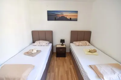 two beds in a room with hats on them at Apartment near Old Town in Budva