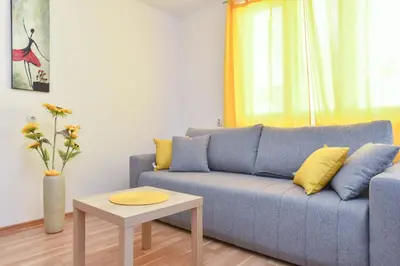 a living room with a blue couch and a table at Apartment near Old Town in Budva