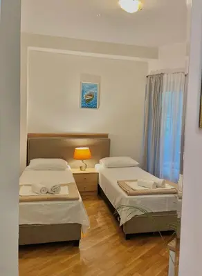 a bedroom with two beds and a lamp and a window at Apartment Kralj in Kotor