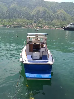a blue and white boat sitting in the water at Apartment Kralj in Kotor