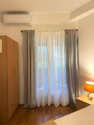 a room with a window with white curtains at Apartment Kralj in Kotor
