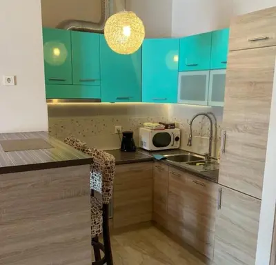a kitchen with blue cabinets and a sink and a microwave at Luxury Apartment Anastasia Tre canne in Budva
