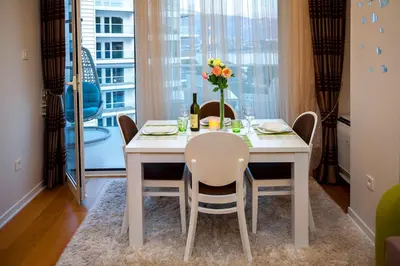 a dining room with a table and chairs and a window at Luxury Apartment Anastasia Tre canne in Budva