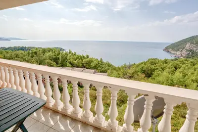 a balcony with a table and a view of the water at Vila Bronhi in Sutomore