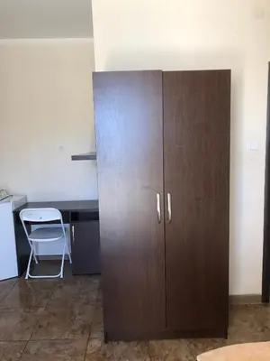a large wooden cabinet in a room with a desk at Vila Bronhi in Sutomore