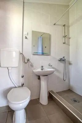 a bathroom with a toilet and a sink and a shower at Vila Bronhi in Sutomore