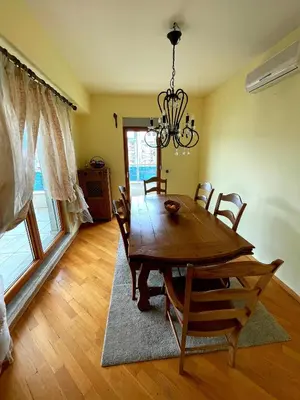a dining room with a wooden table and chairs at Central Rusitc Apartment in Podgorica