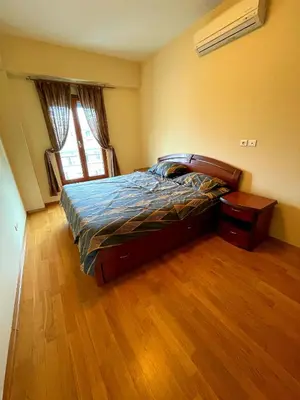a bedroom with a bed and a wooden floor at Central Rusitc Apartment in Podgorica