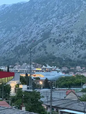 a cruise ship in a harbor with a mountain at the Right Choice Apartment in Kotor