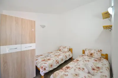 a bedroom with two beds next to a cabinet at the Right Choice Apartment in Kotor