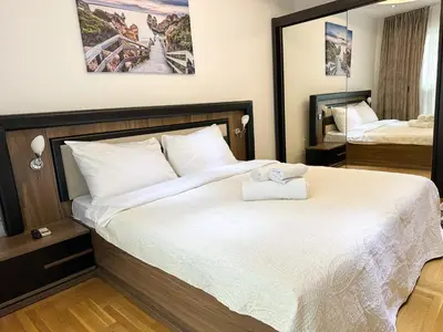 a bedroom with a large bed with white sheets at AvR Barka Budva in Budva