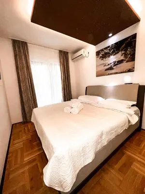 a bedroom with a large bed with white sheets at AvR Barka Budva in Budva