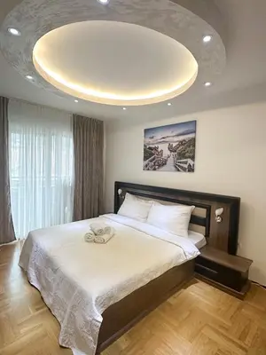 a bedroom with a large bed with a large ceiling at AvR Barka Budva in Budva