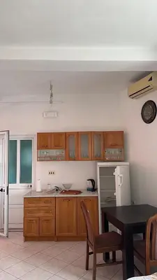 a kitchen with wooden cabinets and a table and a refrigerator at Sea in Ulcinj