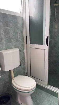 a bathroom with a toilet and a glass shower door at Sea in Ulcinj