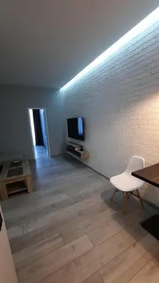 a living room with a television and a white chair at Beach Pearl in Sutomore