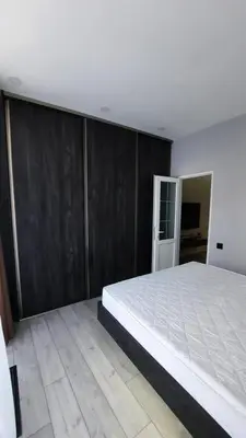 a bedroom with a large bed and a wooden wall at Beach Pearl in Sutomore