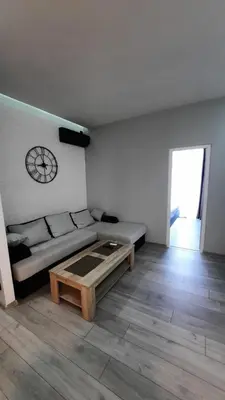 a living room with a couch and a clock on the wall at Beach Pearl in Sutomore
