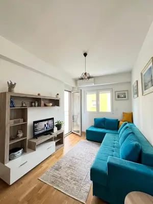 a living room with a blue couch and a tv at Odmor u Podgorici. in Podgorica