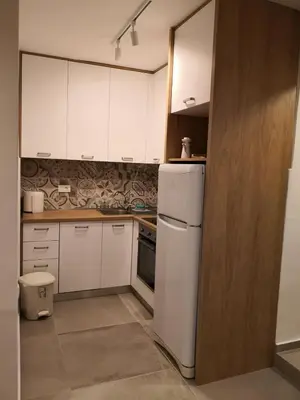 a kitchen with white cabinets and a white refrigerator at Biserni Apartman 1 in Kotor