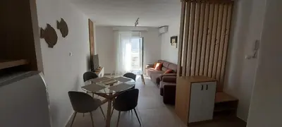a living room with a couch and a table and chairs at Biserni Apartman 1 in Kotor
