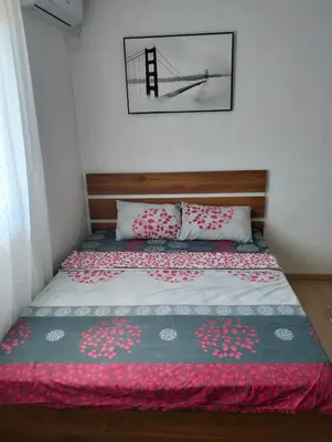 a bedroom with a bed with a red and white blanket at Talic Apartmani in Sutomore